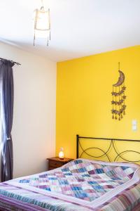 um quarto com uma cama e uma parede amarela em Rural Residence em Skouloúfia