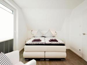 een witte slaapkamer met een wit bed met kussens bij Ferienhaus am Yachthafen in Peenemünde in Peenemünde