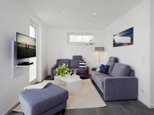 ein Wohnzimmer mit 2 Sofas und einem TV in der Unterkunft Ferienhaus am Yachthafen in Peenemünde in Peenemünde