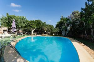 una gran piscina azul en un patio en Casa Marcos, en Son Carrió