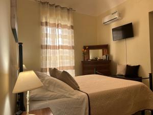 um quarto com uma cama com um candeeiro e um espelho em Sicilian Dream Apartments em Cefalù