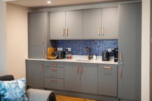 a kitchen with white cabinets and a sink at Kilkenny Suites in Kilkenny