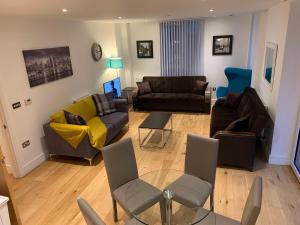 a living room with couches and chairs and a table at Dockland Excel 2 Bedroom Apartment 2 Bathrooms, Balcony, Parking in London