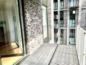 a balcony of a building with a brick wall at Dockland Excel 2 Bedroom Apartment in London