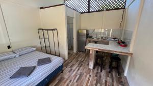 Habitación pequeña con cama y lavamanos en Apartamentos Sol, en Cahuita
