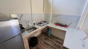 a small kitchen with a sink and a refrigerator at Apartamentos Sol in Cahuita