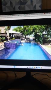 沙帕達－杜斯吉馬朗伊斯的住宿－Águas do Manso Hotel E Marina，带有游泳池照片的电脑显示器