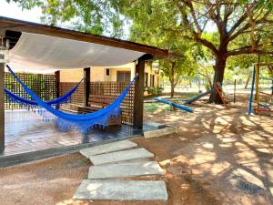 a playground with a blue hammock on a deck at Águas do Manso Hotel E Marina in Chapada dos Guimarães
