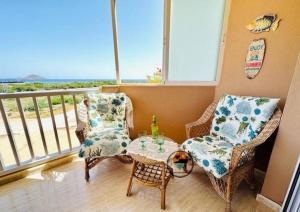 Habitación con 2 sillas, mesa y balcón. en Marinesco 2, 3 bedroom, 2 bathroom apartment, La Manga LMHA06, en San Blas