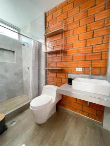 ein Bad mit einem WC, einem Waschbecken und einer Dusche in der Unterkunft Mono ambiente comfortable in Moyobamba