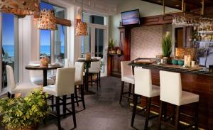 フォート・ローダーデールにあるペリカン グランド ビーチ リゾート ア ノーブル ハウス リゾートの白い椅子と窓のあるレストランのバー
