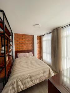 ein Schlafzimmer mit einem Bett und einer Ziegelwand in der Unterkunft Mono ambiente comfortable in Moyobamba