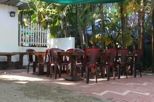 a group of chairs and a wooden table and chairs at Royal Devbaug Holiday Home in Malvan