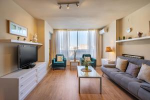 een woonkamer met een bank en een tv bij Apartamento Alminar in Granada