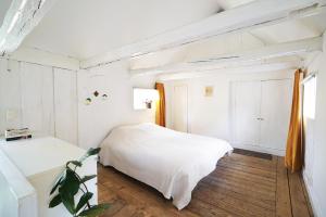 a white bedroom with a bed and a window at The architects' house in Stockholm