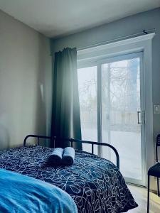 een slaapkamer met een bed en een groot raam bij O Canada Guest House in Toronto