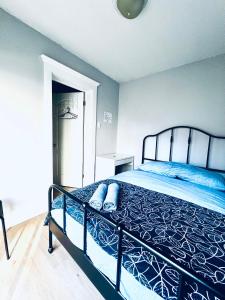 um quarto com uma cama com um edredão azul em O Canada Guest House em Toronto