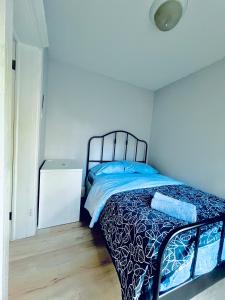 a bedroom with a bed with a blue comforter at O Canada Guest House in Toronto