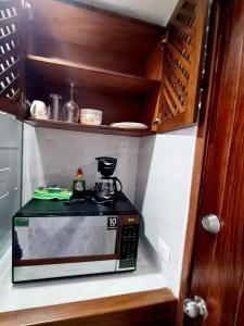 un four micro-ondes installé sur une étagère dans une cuisine dans l'établissement Hotel los tules 12-501, à Puerto Vallarta