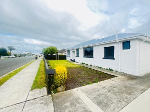 uma casa branca ao lado de uma rua em Double bed room in Invercagill/5mini walk to city em Invercargill