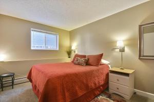 a bedroom with a bed with a red bedspread and a window at Tannhauser 225 in Breckenridge