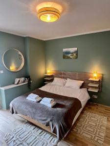 a bedroom with a large bed and a large mirror at Apartament Lucjanek in Karpacz