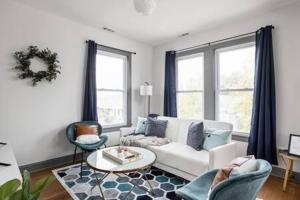 a living room with a white couch and two chairs at Modern Architect's Duplex by CozySuites in Indianapolis