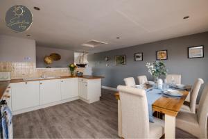 a kitchen and dining room with a table and chairs at Leeward House - Luxury, Spacious, Sea View Apartment, Parking, Central Lymington in Lymington