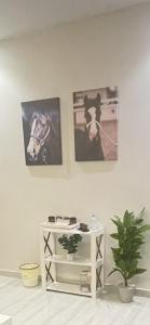 une chambre avec deux photos d'un cheval sur le mur dans l'établissement شقة فاخرة غرفة نوم وصالة, à Riyad