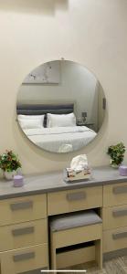 - une chambre avec un lit et un grand miroir dans l'établissement شقة فاخرة غرفة نوم وصالة, à Riyad