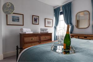 a bottle of champagne sitting on a table in a bedroom at Leeward House -Solent views, Parking,High Street Location, Couples, Groups, Families and Professionals Welcome in Lymington