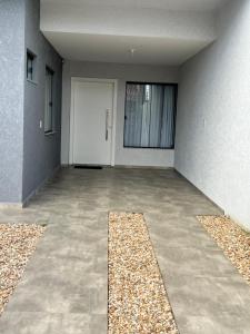 an empty room with a white door and a hallway at Sobrado Home beach, 4 suites, piscina privativa e conforto expecional in Piçarras
