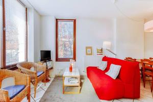 a living room with a red couch and a table at Cabana & Le Paisible - Proche Lac in La Pirraz