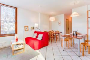 a living room with a red couch and a table at Cabana & Le Paisible - Proche Lac in La Pirraz