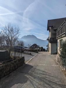 an empty street with a mountain in the background at Cabana & Le Paisible - Proche Lac in La Pirraz