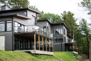 Casa situada en una colina con balcón grande en Auberge de la Montagne Coupée en Saint-Jean-de-Matha