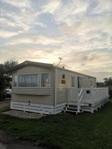 una casa móvil está estacionada en el césped en Lovely Caravan With Decking At Solent Breeze In Hampshire Ref 38195sb en Warsash