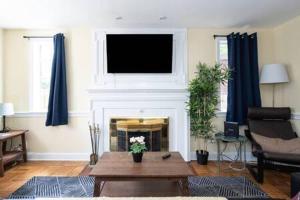 a living room with a fireplace with a tv above it at Spacious 4BR CozySuites in Old Town Alexandria in Alexandria