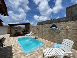 une piscine avec deux chaises et une terrasse avec une piscine dans l'établissement Casa Dona Van Van Praia do Francês, à Marechal Deodoro
