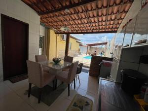 - une cuisine et une salle à manger avec une table et des chaises dans l'établissement Casa Dona Van Van Praia do Francês, à Marechal Deodoro