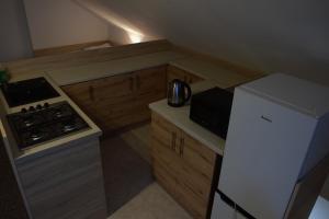 uma pequena cozinha com um fogão e um frigorífico em Apartament Czos Kominek Premium em Mrągowo