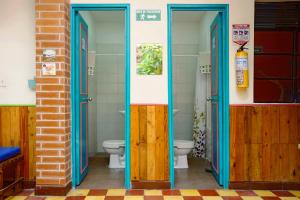 a bathroom with two doors and a toilet at Ding-Dong Hostel in Cali