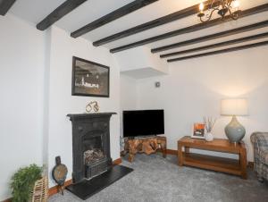 a living room with a fireplace and a flat screen tv at 5 The Crescent in Caernarfon