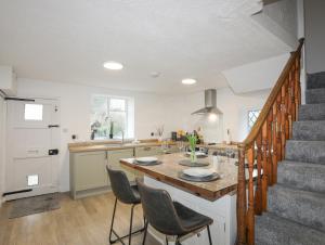a kitchen with a table and chairs and a staircase at 5 The Crescent in Caernarfon