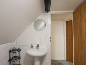 a white bathroom with a sink and a staircase at 5 The Crescent in Caernarfon +25 photos