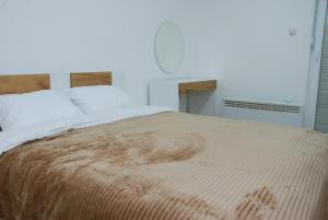 1 dormitorio con 1 cama grande con manta marrón en Apartman Delevi, en Strumica