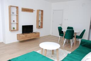 a living room with a couch and a table and a tv at Apartman Delevi in Strumica