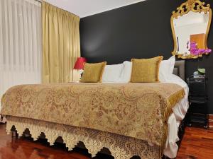 um quarto com uma cama grande e um espelho dourado em ANA FRANK Boutique Hotel em Lima