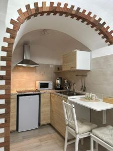 a kitchen with an archway and a white refrigerator at Amaré Guest House in Naples
