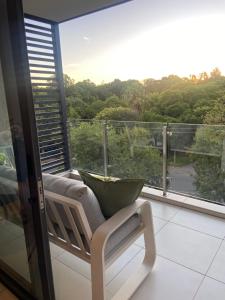 a balcony with a bench and a large window with a view at Load-Shedding Free Trendy 2-bed 2-bath Apartment in Johannesburg